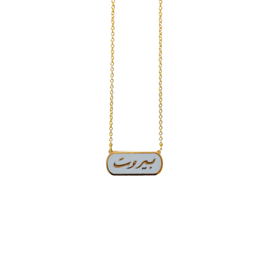 A gold-plated necklace with a rectangular pendant inscribed with 'Beirut' in Arabic script, attached to a chain with a lobster claw closure.