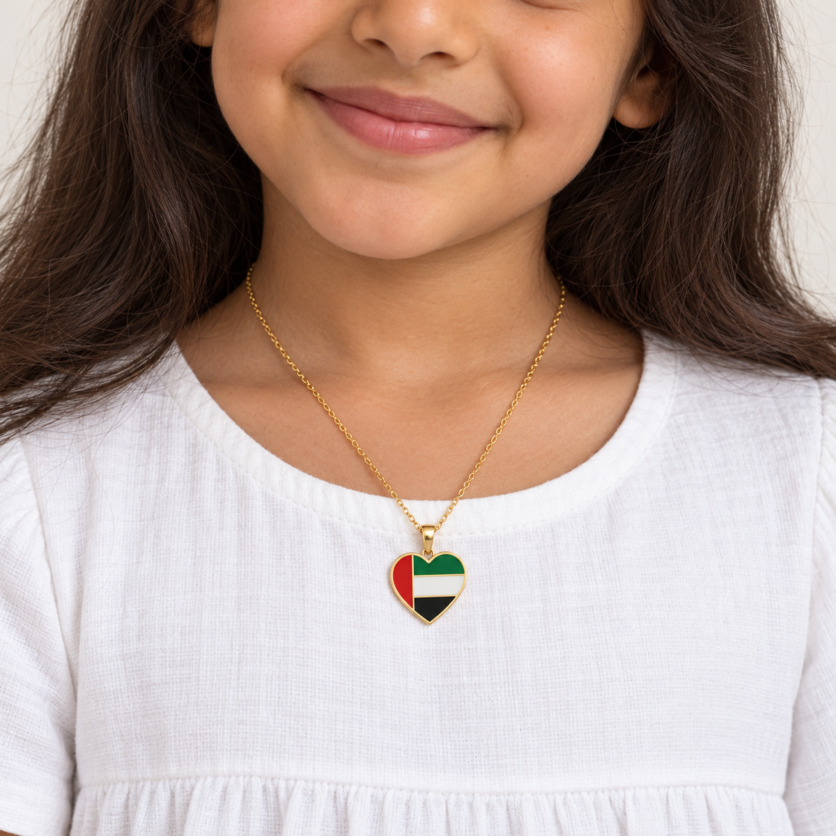 Generated child model wearing UAE flag heart enamel necklace — styling mockup
