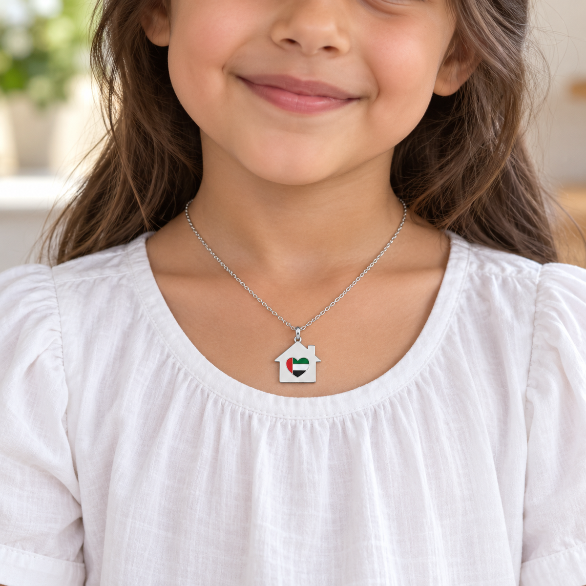 Child wearing My UAE Home 2 × 2 cm silver finish house necklace with UAE flag heart — generated styling image