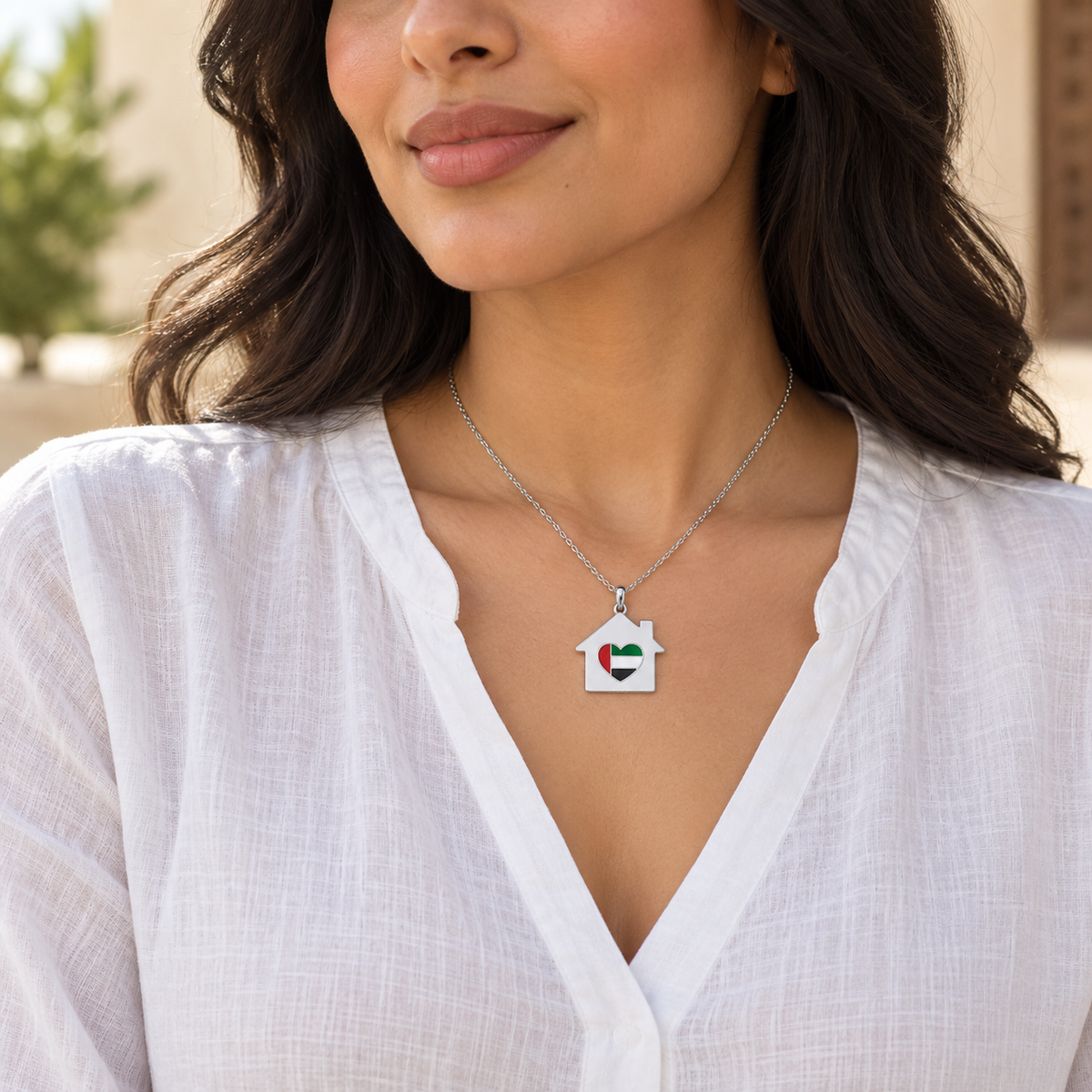 Woman wearing My UAE Home 3 × 3 cm silver finish house necklace with UAE flag heart — generated styling image
