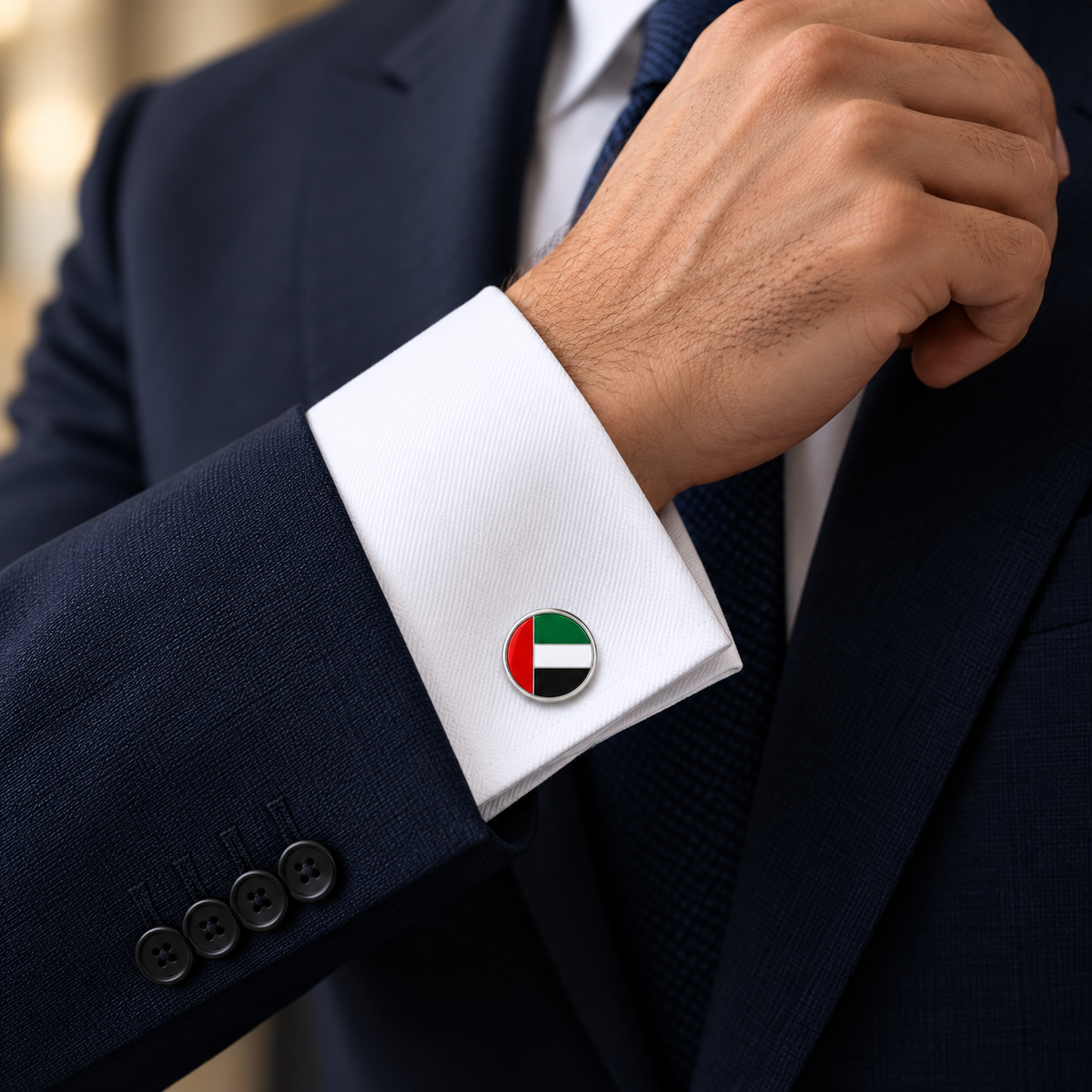 Round UAE flag cufflink worn with a navy suit and white French cuff